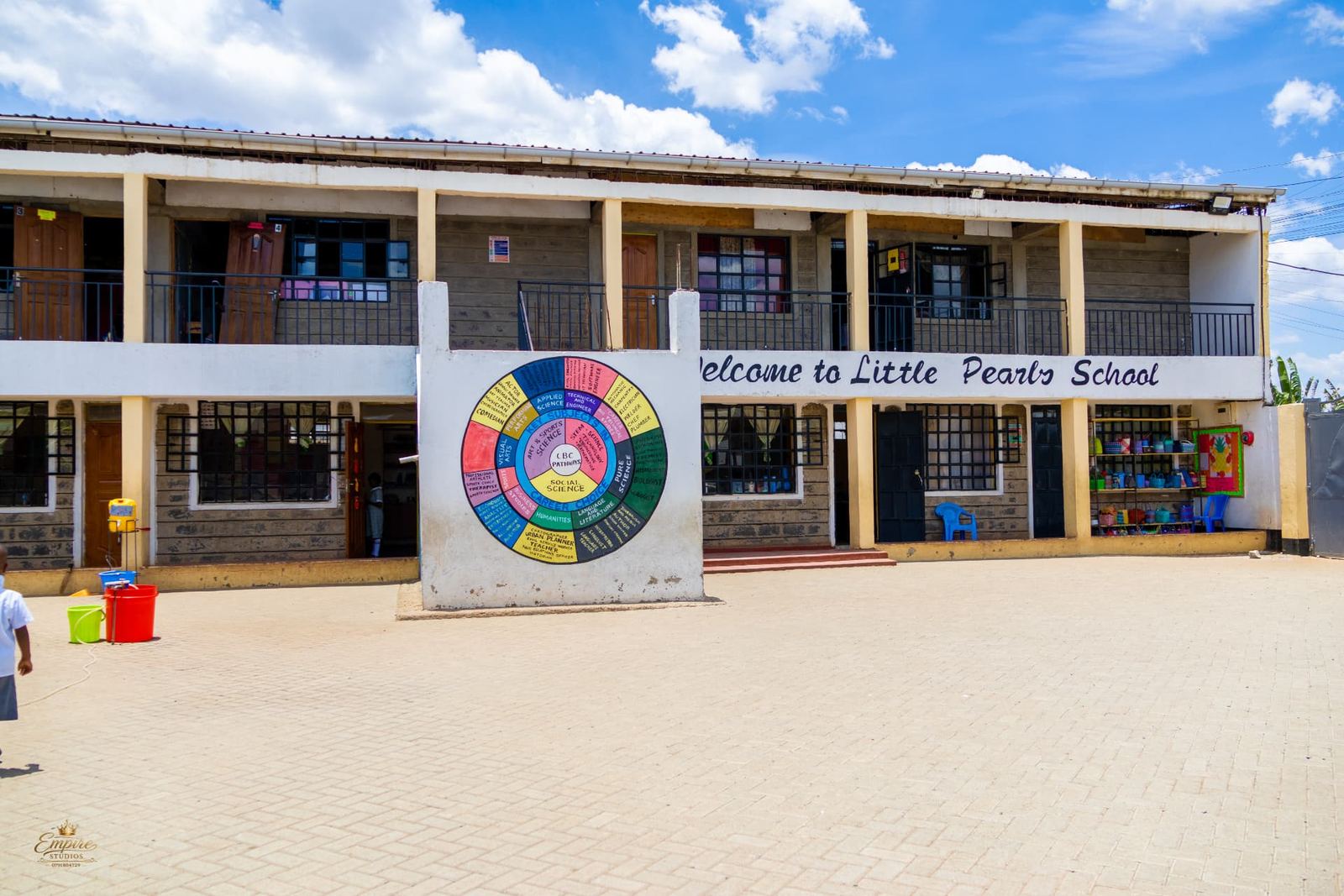 The main Little Pearls School building with its welcome sign and CBC pathways mural